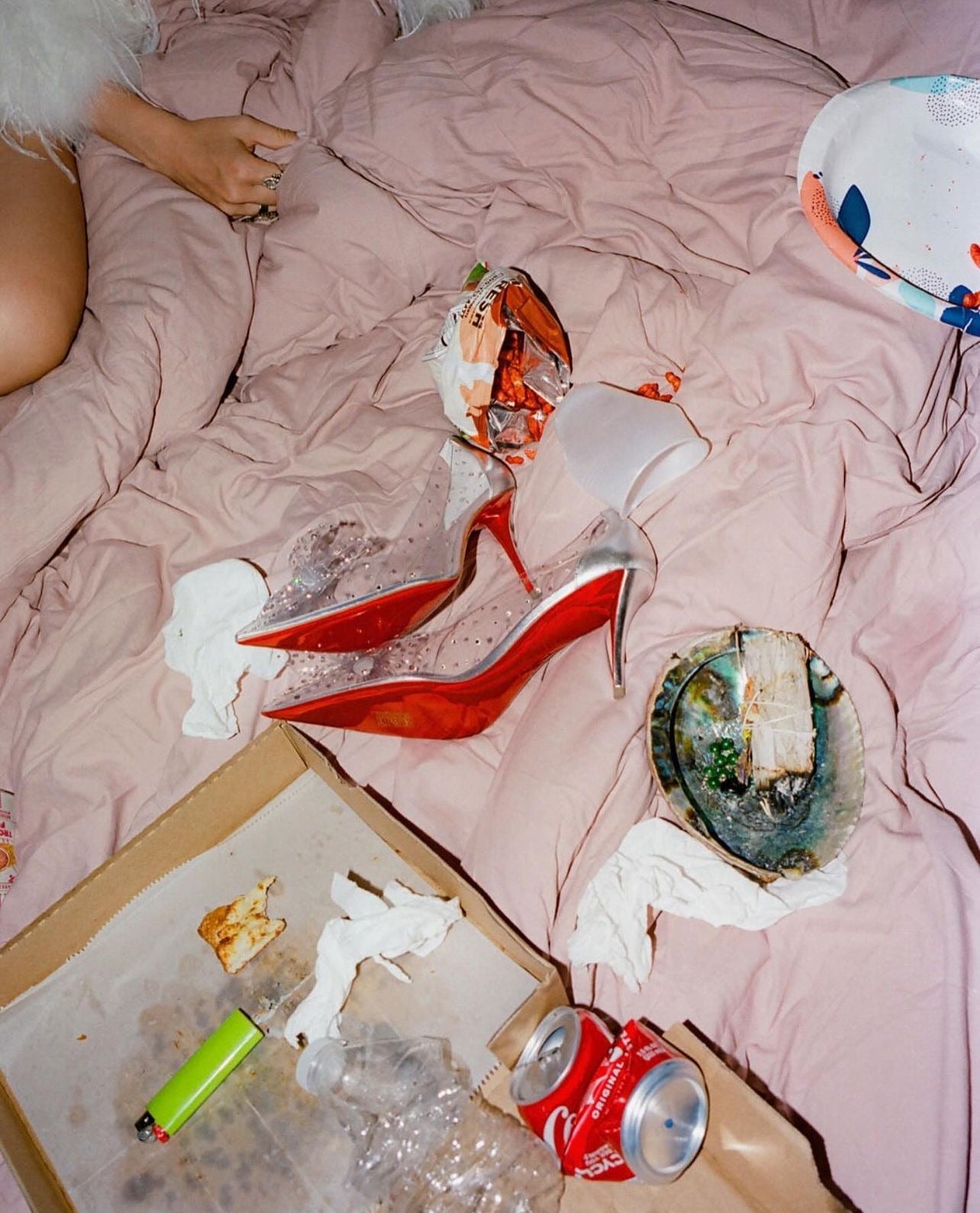 image of a pair of high heels on top of a pink bed with la saum olive brine next to them