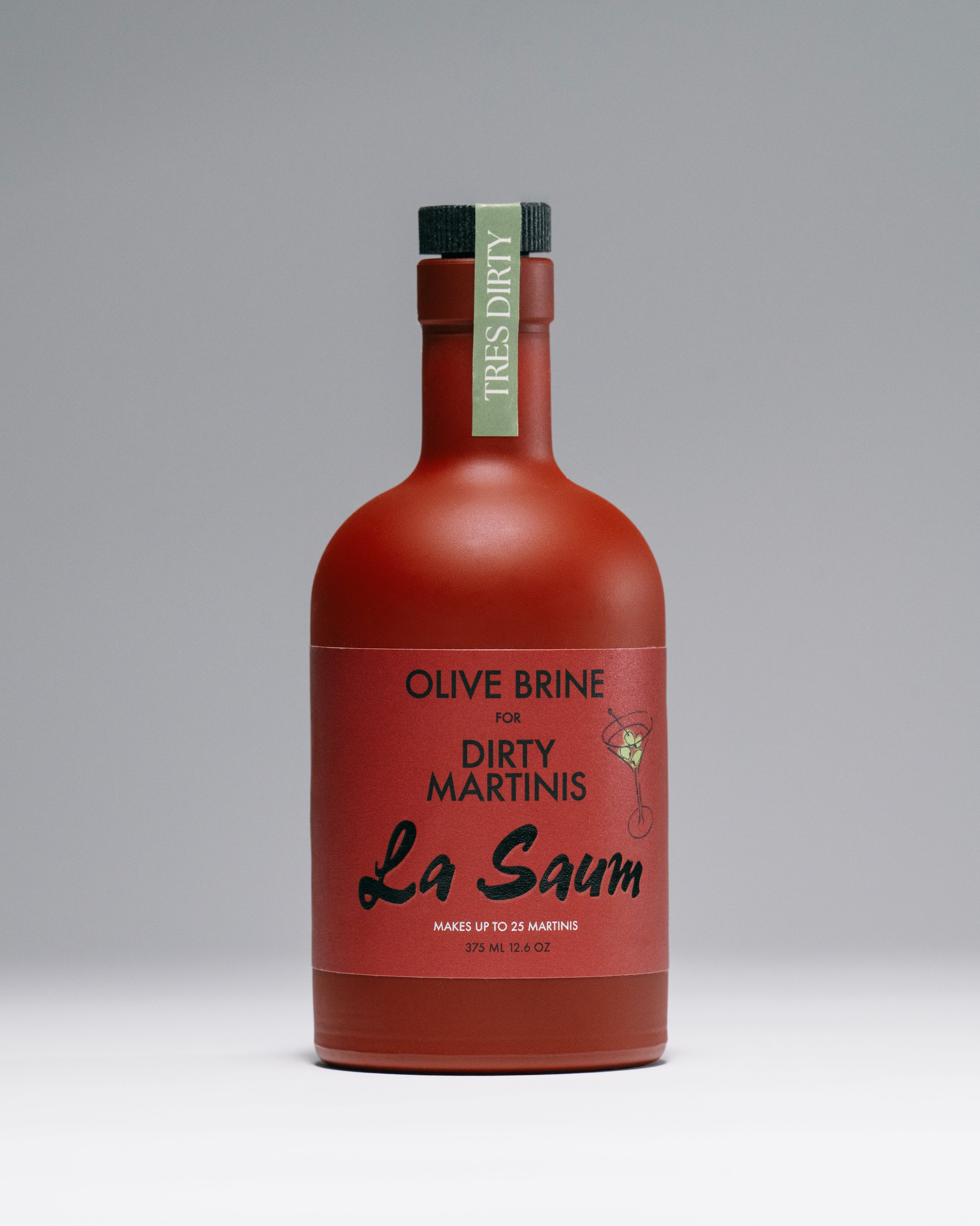 Red bottle of La Saum olive brine for dirty martinis on a gray background