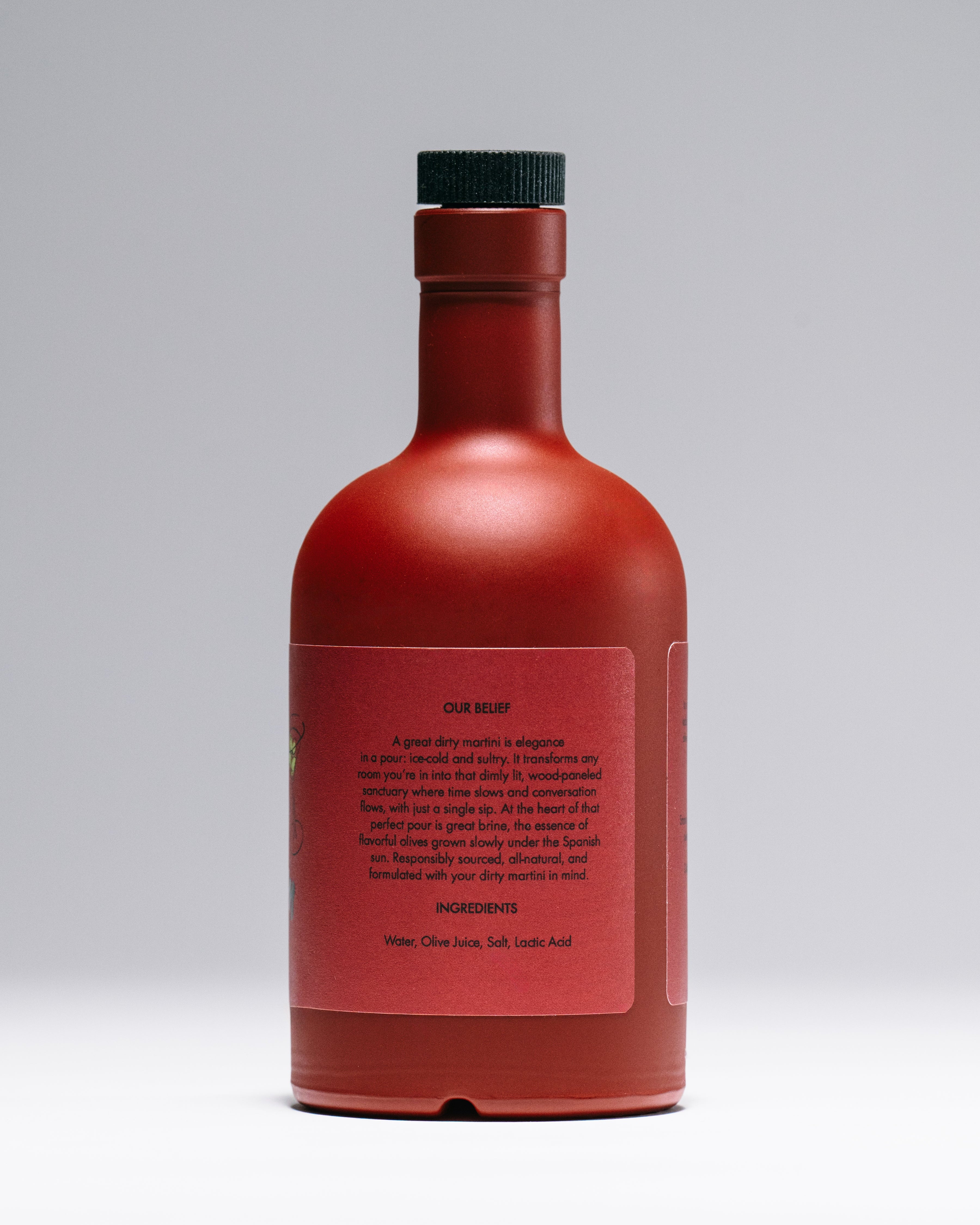 La Saum Red bottle with a black cap on a black background