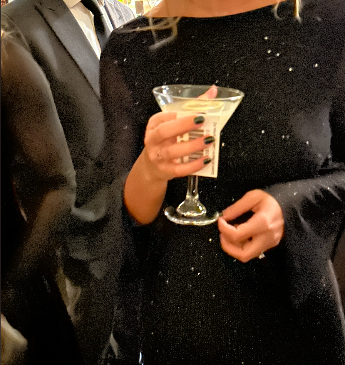 woman in a black dress drinking a dirty gibson cocktail