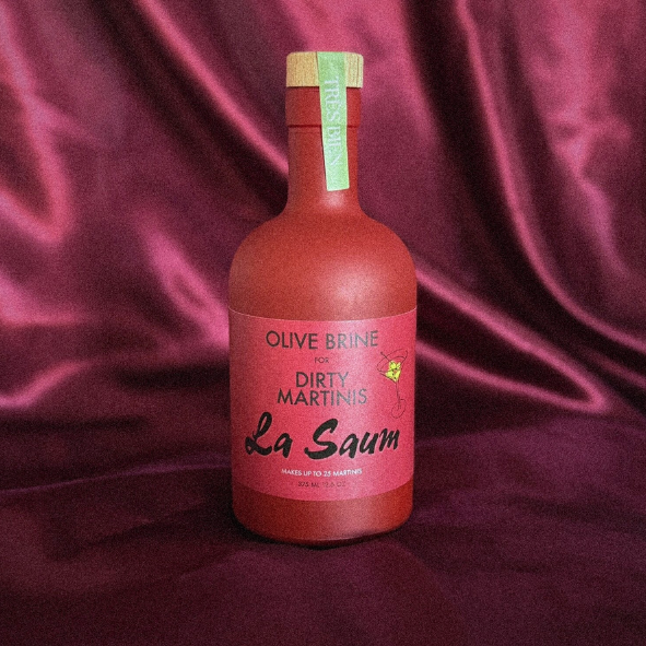 Bottle of Olive Brine Dirty Martini La Saum on a maroon fabric background